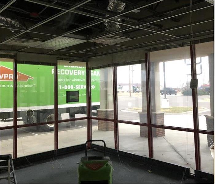 no ceiling tiles in a commercial office a dehumidifier, clear glass building you can see a green truck parked 